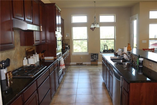 kitchen featuring light tile patterned floors, stainless steel appliances, backsplash, a sink, and under cabinet range hood