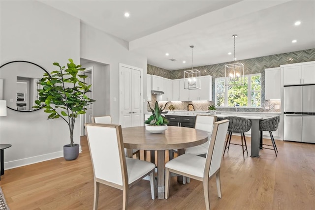 dining space with light wood-style floors, baseboards, a chandelier, and recessed lighting