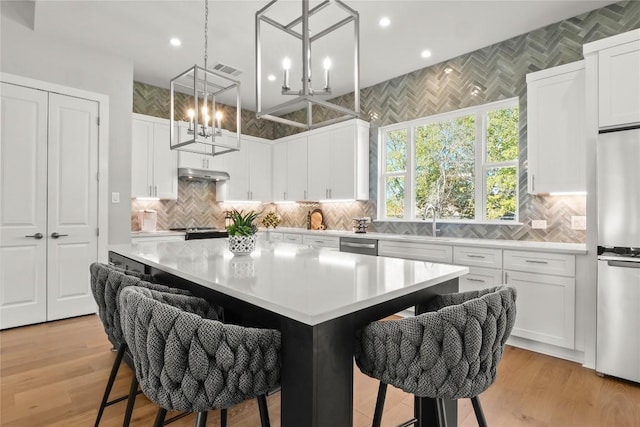 kitchen with stainless steel appliances, light countertops, visible vents, and under cabinet range hood