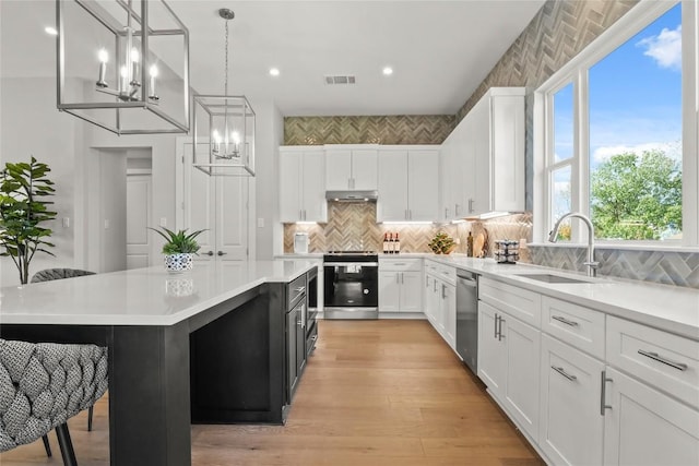 kitchen with electric range, visible vents, dishwasher, light countertops, and a sink