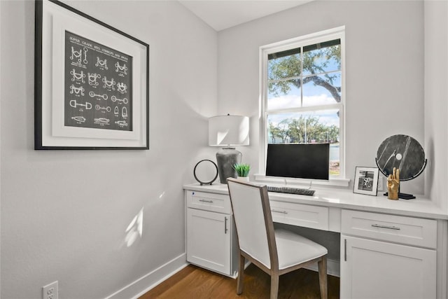 office with wood finished floors, built in study area, and baseboards