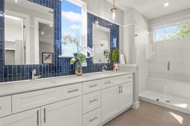 full bath with a stall shower, a sink, and backsplash