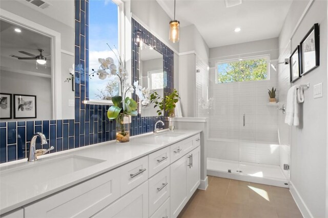 bathroom featuring double vanity, a stall shower, tasteful backsplash, and a sink