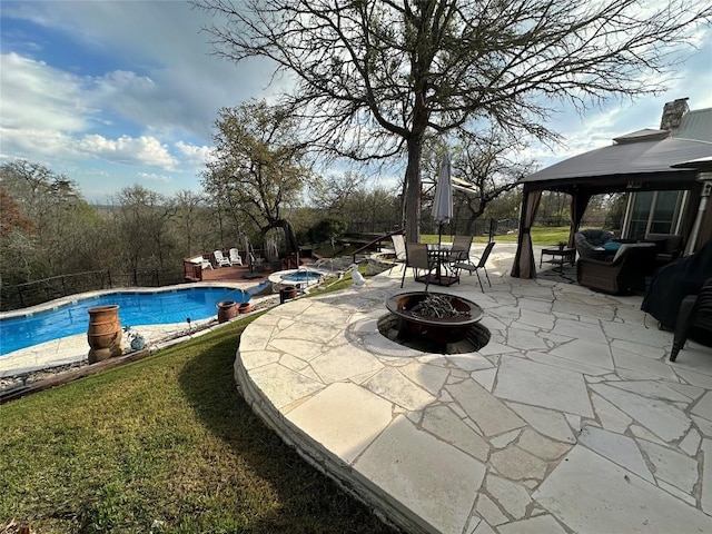 community pool with an outdoor fire pit, fence, a patio, and a gazebo