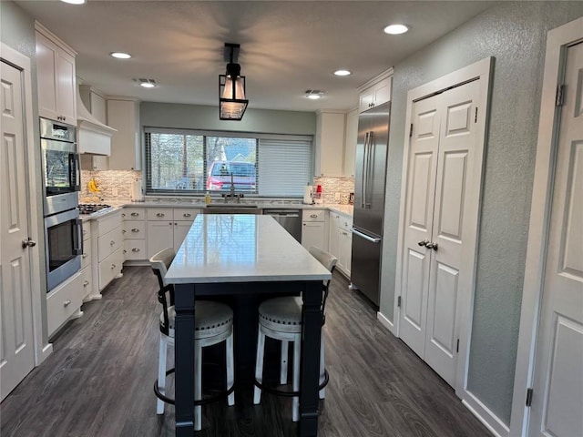 kitchen with white cabinetry, appliances with stainless steel finishes, and dark wood-type flooring