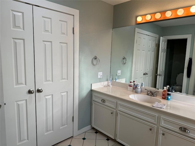 bathroom featuring toilet, vanity, and baseboards