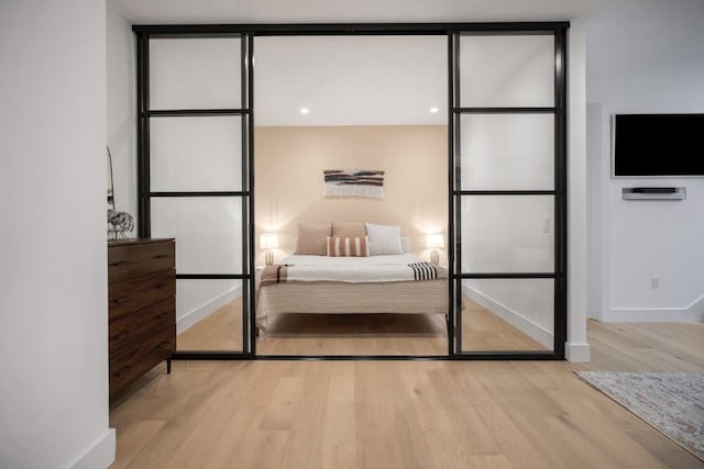 bedroom with baseboards, wood finished floors, and floor to ceiling windows