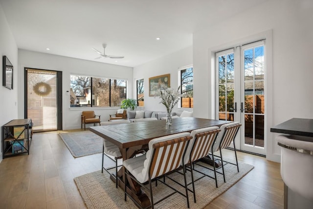 dining area with a healthy amount of sunlight, recessed lighting, wood finished floors, and french doors