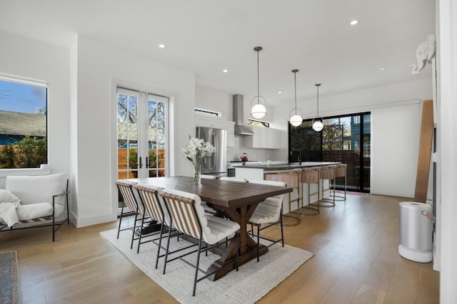 dining area featuring light wood-style floors, recessed lighting, and french doors