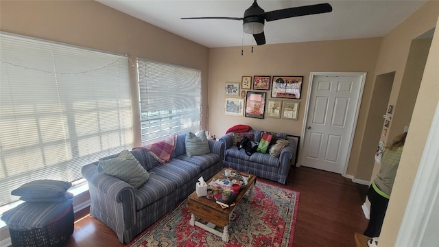 living area featuring a ceiling fan, baseboards, and wood finished floors