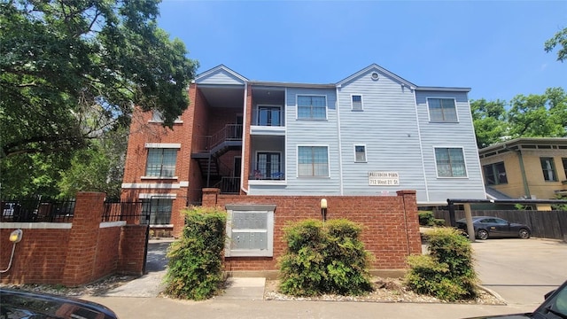 view of front of home featuring brick siding and fence