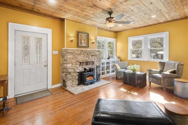 living room with ornamental molding, a ceiling fan, wood ceiling, wood finished floors, and baseboards