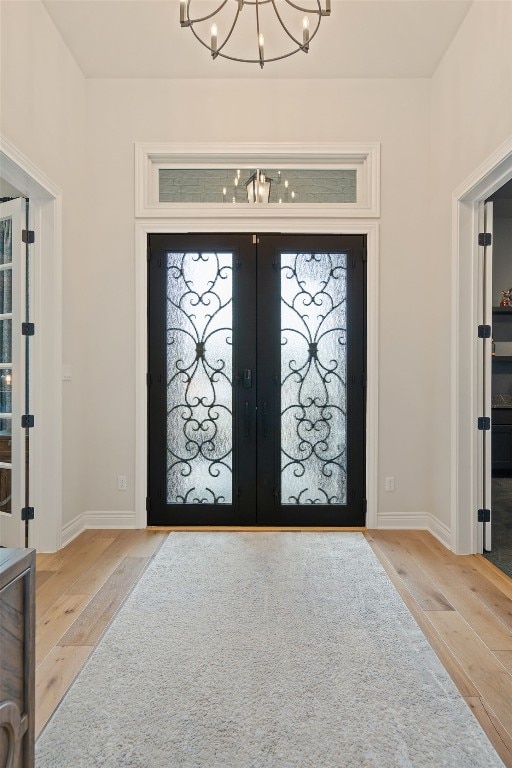 1000 Flint Ridge Trl, Georgetown, TX 78628 - foyer entrance with a chandelier, french doors, wood-type flooring, and baseboards