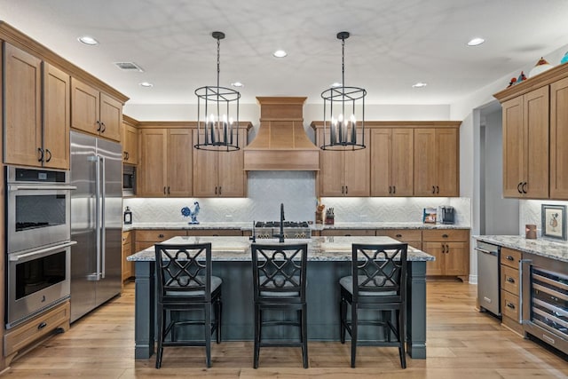 1000 Flint Ridge Trl, Georgetown, TX 78628 - kitchen featuring built in appliances, beverage cooler, custom exhaust hood, a chandelier, and decorative light fixtures