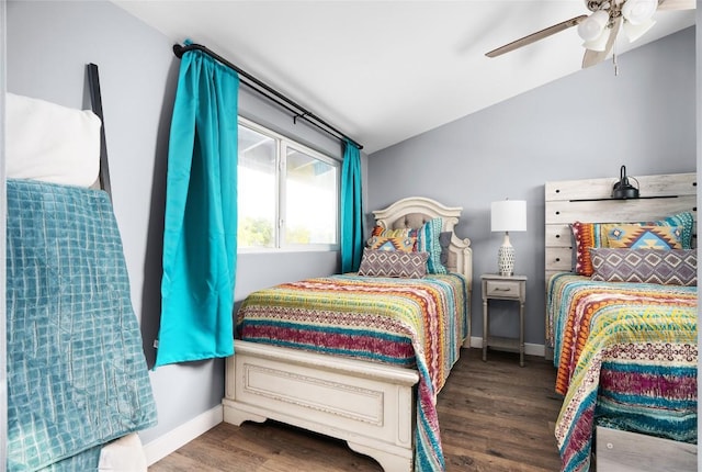 bedroom with vaulted ceiling, wood finished floors, a ceiling fan, and baseboards