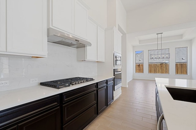 1832 Camay St, Leander, TX 78641 - kitchen featuring ventilation hood, stainless steel appliances, tasteful backsplash, white cabinets, and light countertops