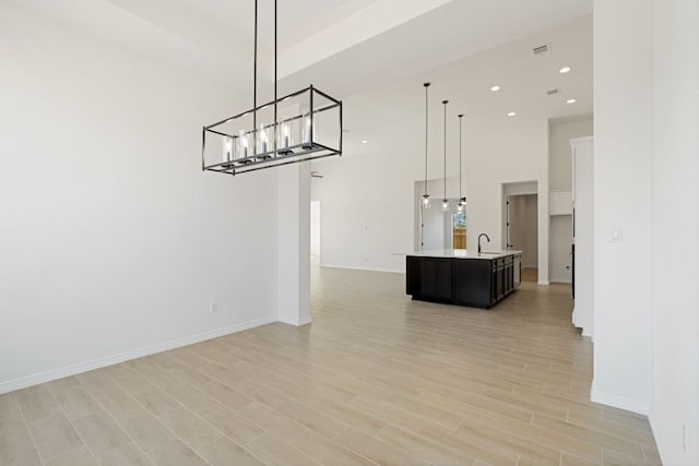 1832 Camay St, Leander, TX 78641 - unfurnished dining area with a towering ceiling, light wood-style floors, a chandelier, and recessed lighting