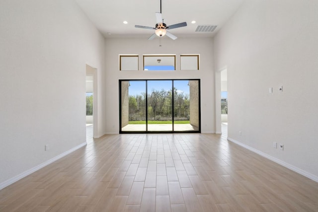 1832 Camay St, Leander, TX 78641 - unfurnished living room featuring plenty of natural light, ceiling fan, a towering ceiling, light wood-type flooring, and recessed lighting