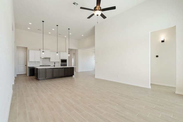 1832 Camay St, Leander, TX 78641 - unfurnished living room featuring a towering ceiling, a ceiling fan, recessed lighting, and light wood finished floors