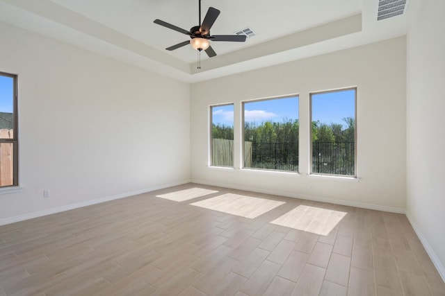 1832 Camay St, Leander, TX 78641 - unfurnished room with a tray ceiling, light wood-style floors, and a ceiling fan