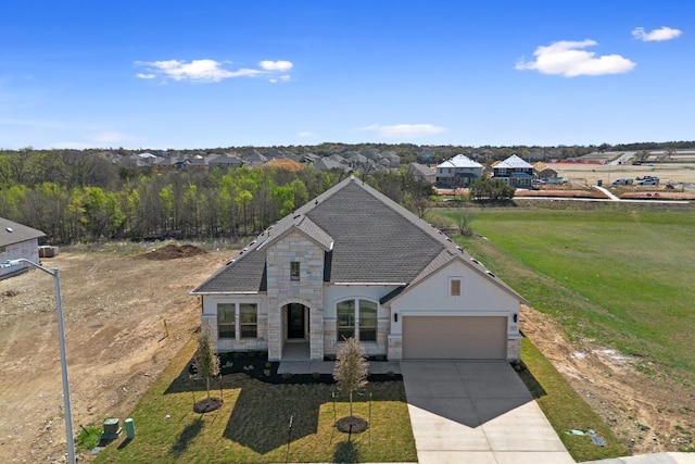 1832 Camay St, Leander, TX 78641 - french country home with stone siding, a garage, concrete driveway, and a front lawn