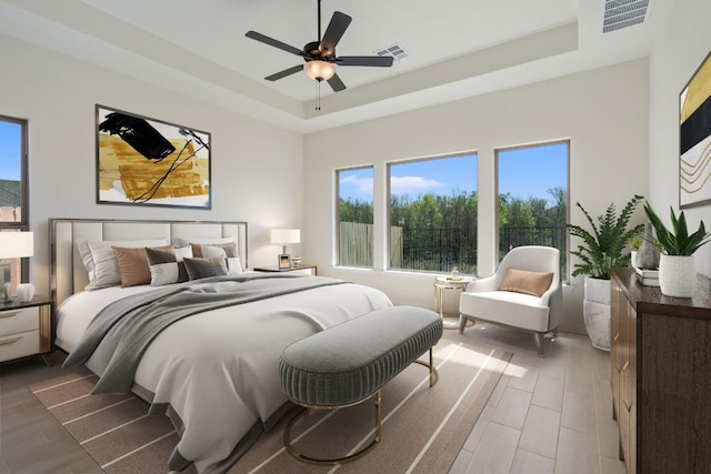 1832 Camay St, Leander, TX 78641 - bedroom featuring a tray ceiling, multiple windows, wood finished floors, and a ceiling fan