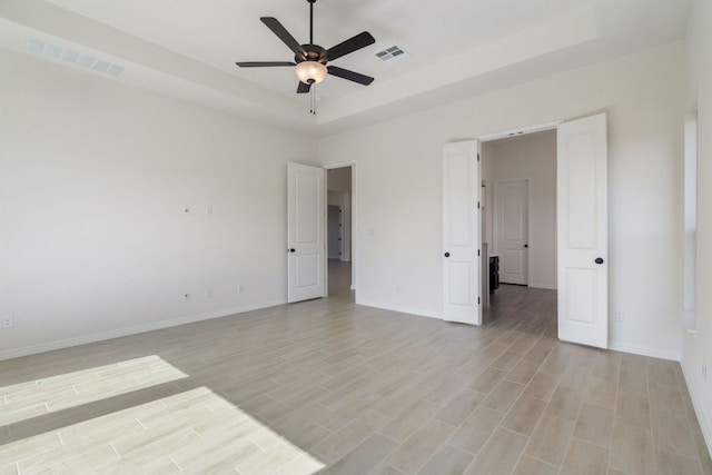 1832 Camay St, Leander, TX 78641 - spare room with ceiling fan, light wood-style flooring, and a tray ceiling