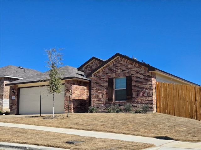 ranch-style home featuring brick siding, an attached garage, and fence