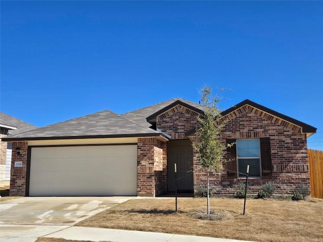 single story home with brick siding, driveway, an attached garage, and roof with shingles