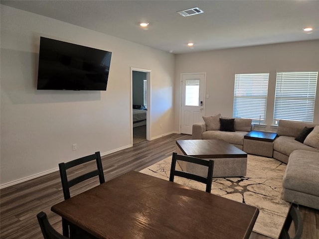 living area featuring baseboards, visible vents, wood finished floors, and recessed lighting