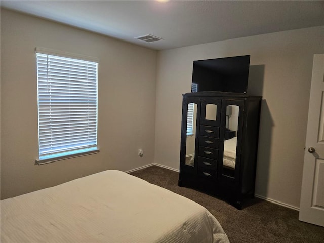 bedroom featuring dark colored carpet, visible vents, and baseboards