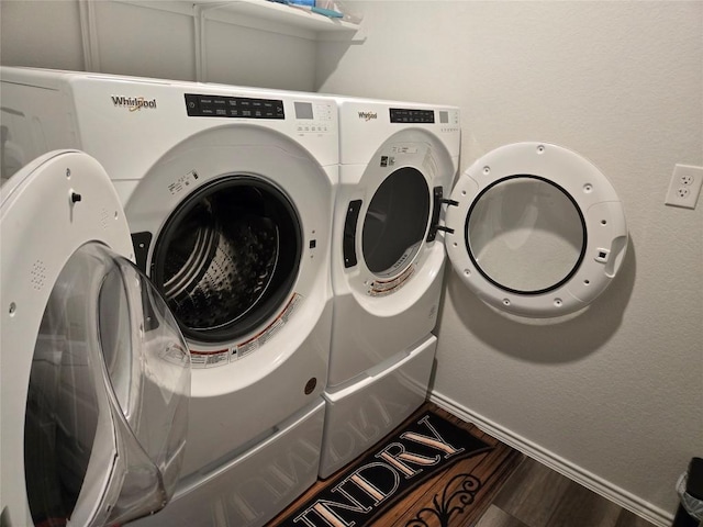 clothes washing area with wood finished floors and washer and dryer