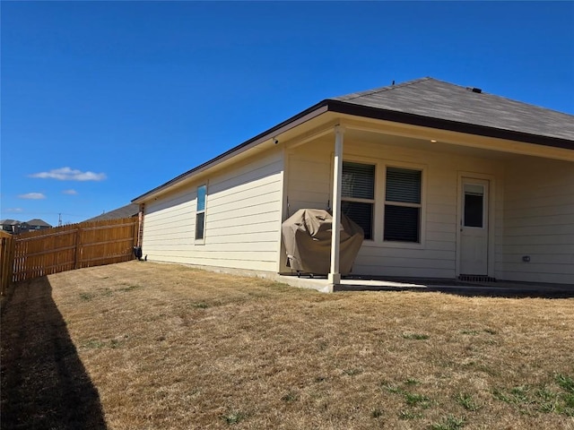 back of property with fence and a lawn