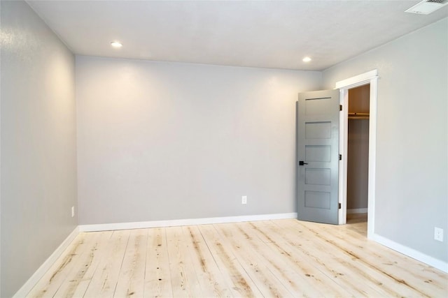 spare room with recessed lighting, wood finished floors, visible vents, and baseboards