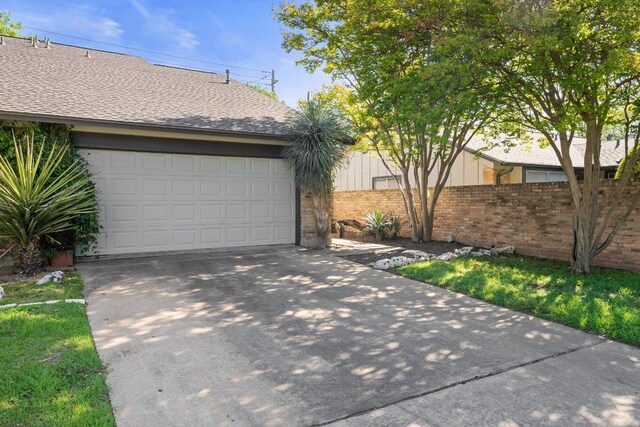 view of front of home with fence, brick siding, a garage, and driveway