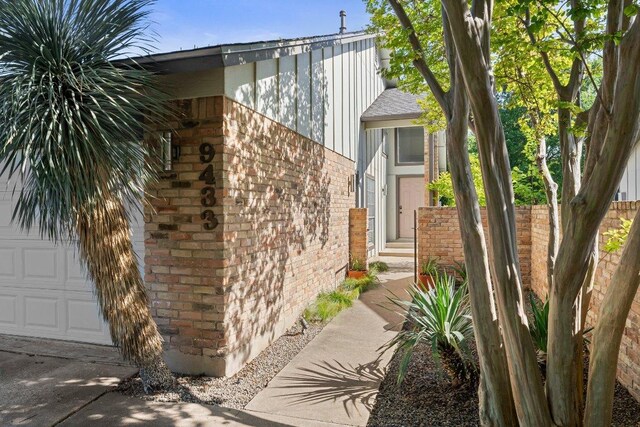 view of side of property with brick siding and fence