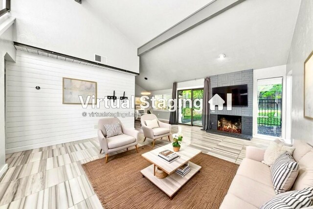tiled living room featuring a fireplace, high vaulted ceiling, and beamed ceiling