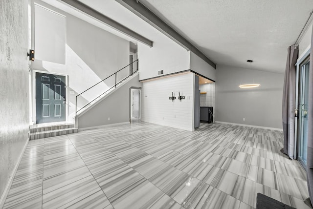unfurnished living room with a textured ceiling, stairway, tile patterned floors, and baseboards