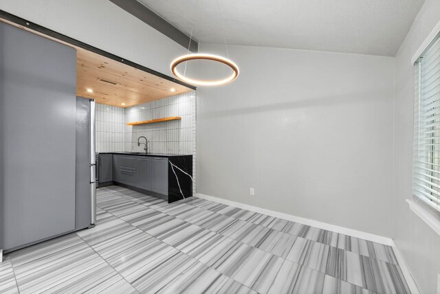 kitchen with dark countertops, open shelves, gray cabinets, a sink, and recessed lighting