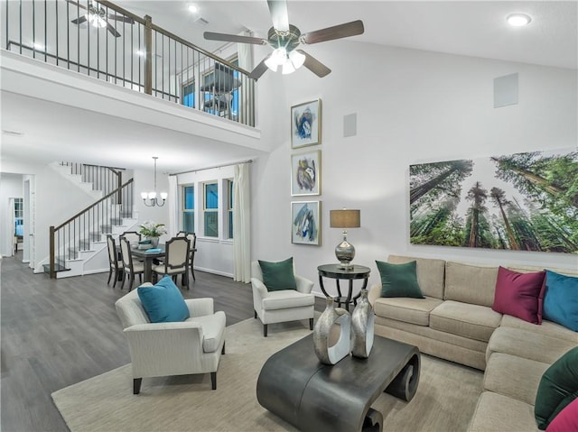 205 Bluff Creek Ln, Georgetown, TX 78628 - living area featuring stairs, wood finished floors, a high ceiling, a ceiling fan, and a chandelier