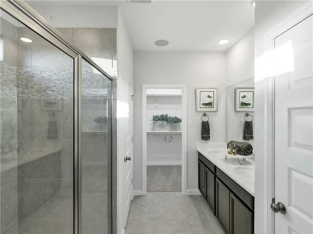 205 Bluff Creek Ln, Georgetown, TX 78628 - full bath featuring double vanity, a shower stall, a spacious closet, tile patterned flooring, and recessed lighting