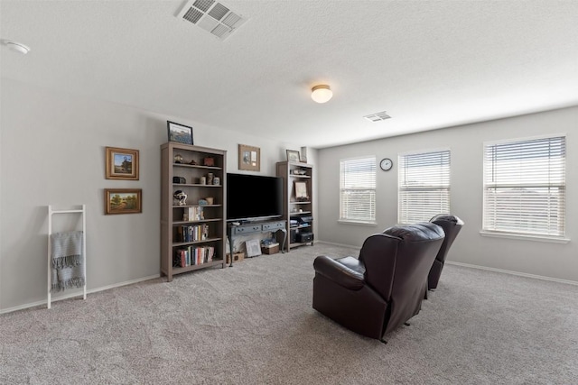 carpeted living room featuring a textured ceiling, visible vents, and baseboards