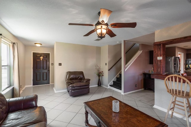 103 Ryan Cv, Hutto, TX 78634 - living area with stairway, light tile patterned floors, and a ceiling fan