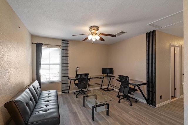 103 Ryan Cv, Hutto, TX 78634 - office area with attic access, wood finished floors, a textured wall, ceiling fan, and a textured ceiling