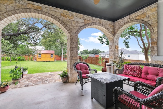 view of patio / terrace with an outbuilding, a storage shed, a fenced backyard, and an outdoor living space