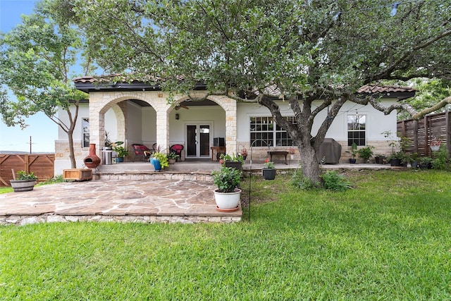 back of property featuring a patio, fence, a lawn, and french doors