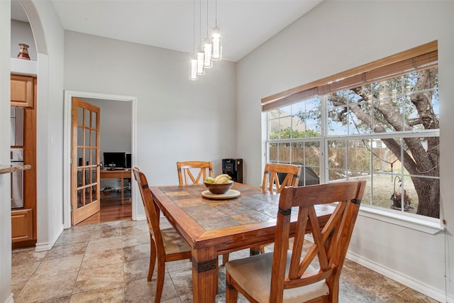 dining room with baseboards, arched walkways, and a notable chandelier