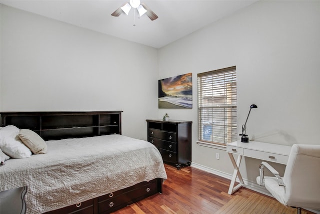 bedroom with a ceiling fan, baseboards, and wood finished floors