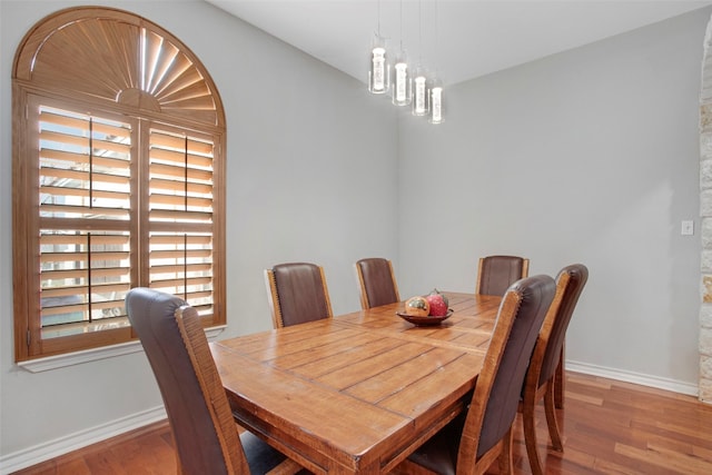 dining space with baseboards and wood finished floors