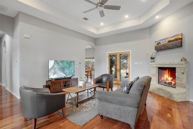 9609 Bluegrass Dr, Austin, TX 78759 - living room with arched walkways, hardwood / wood-style floors, a stone fireplace, a ceiling fan, and recessed lighting